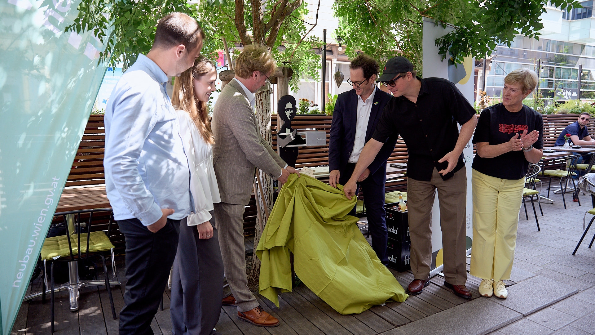 Die Bezirksvorsteher Markus Reiter und Martin Fabisch enthüllen gemeinsam mit Silke Grell, Lorena Riegler und Erwin Lehner die erste GOLIF-Pfandkellner*innen-Figur.