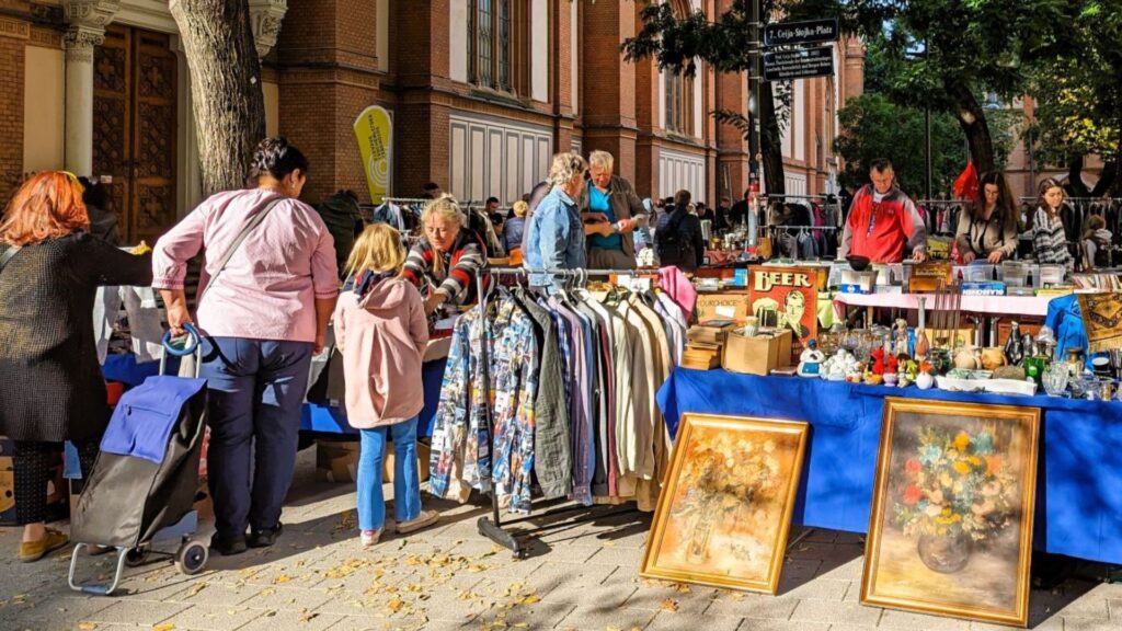 Besucherinnen und Besucher stöbern am Flohmarkt auf der Lerchenfelder Straße zwischen Kleidung, Büchern, Kunstwerken und Vintage-Artikeln.