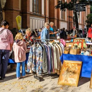 Besucherinnen und Besucher stöbern am Flohmarkt auf der Lerchenfelder Straße zwischen Kleidung, Büchern, Kunstwerken und Vintage-Artikeln.